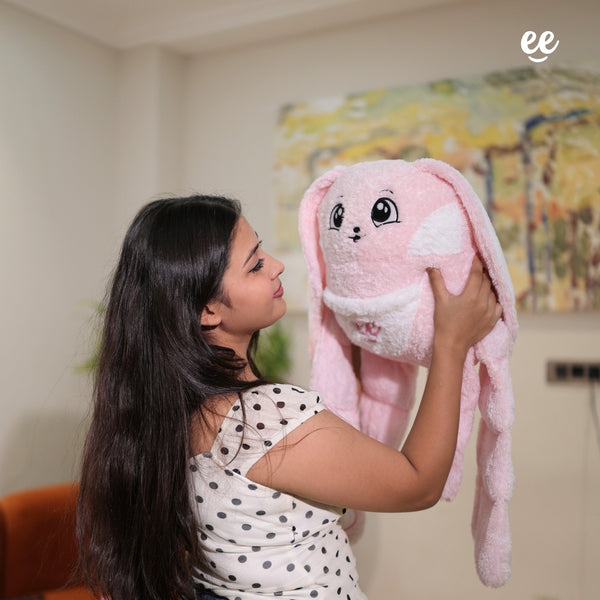 Woman hugging Warmlee pink weighted plushie with its arms over her shoulders